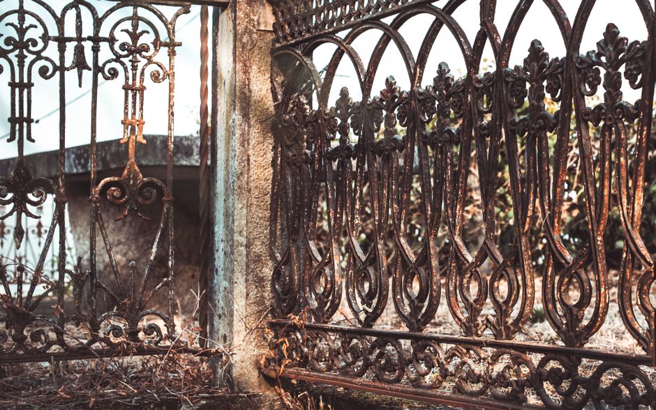 Detailed image of a weathered iron fence in Galicia, showcasing vintage art elements.