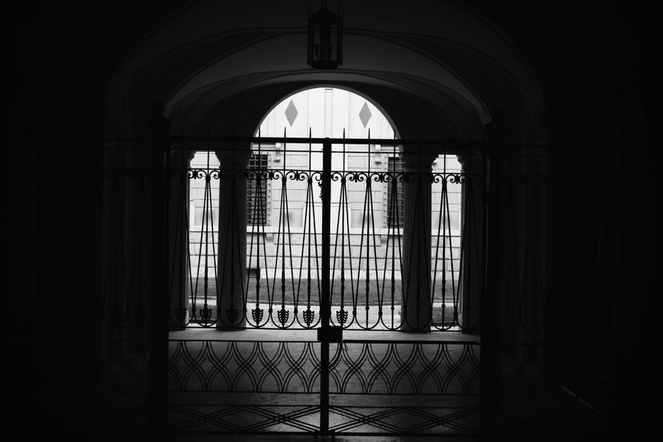 Monochrome silhouette of an elegant gate with arched architecture creating a dramatic contrast.